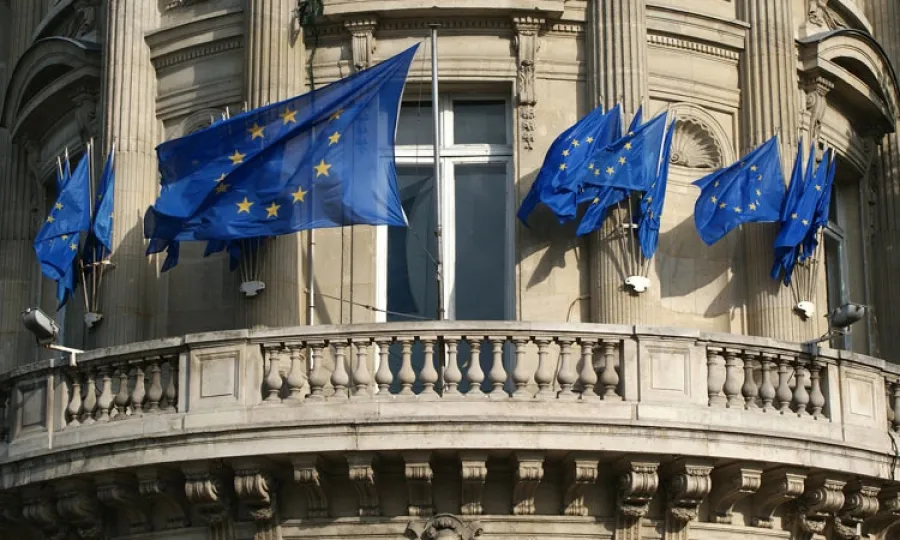 Image of several EU flags on a building balcony